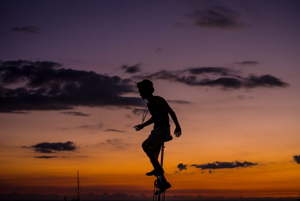 person riding a unicycle in front of a sunset
