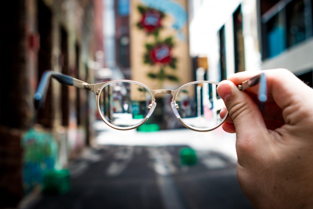 person looking into an alley in the daytime through eyeglasses
