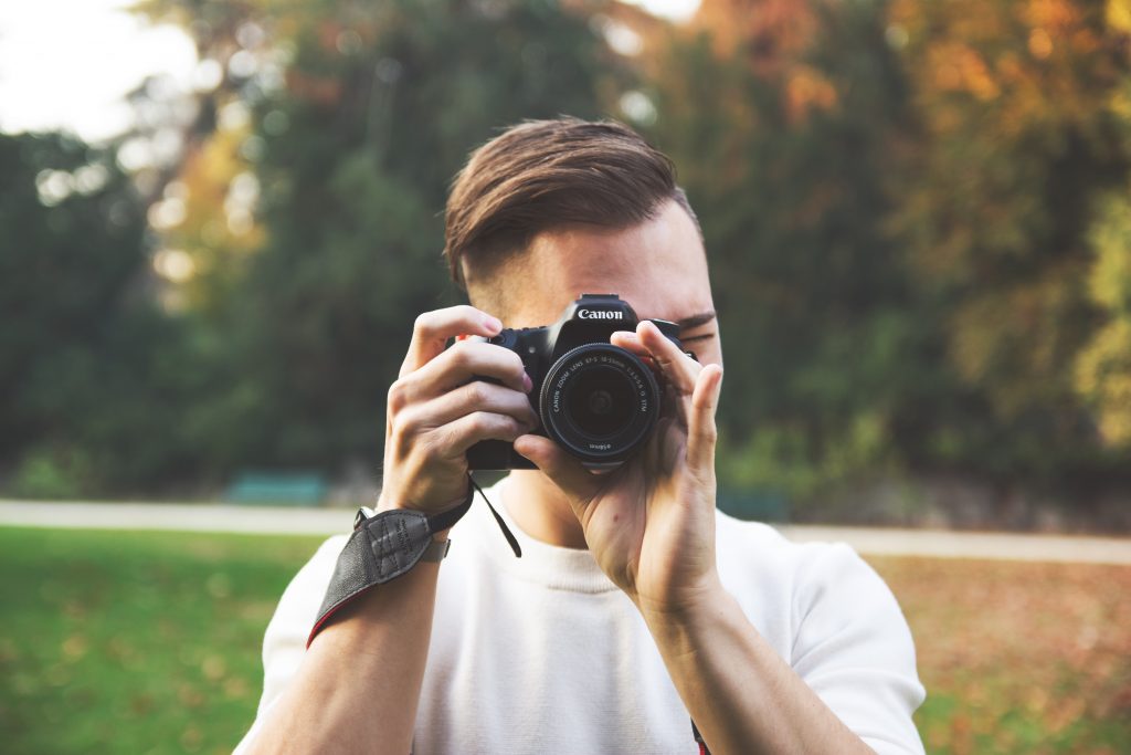 man focusing camera lens