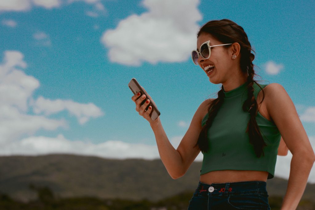 girl outside smiling at phone