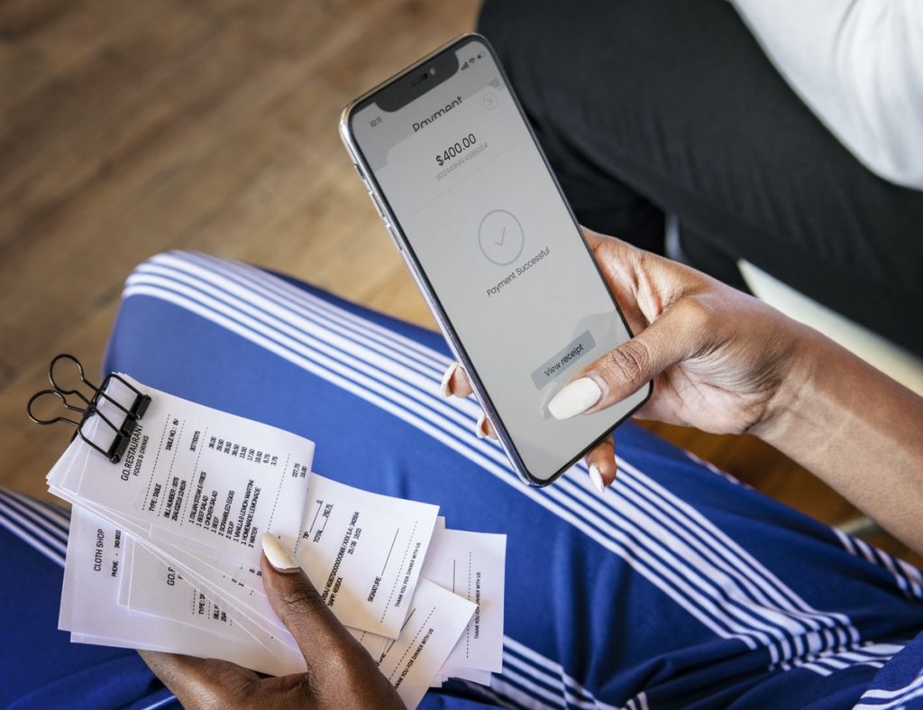woman calculating receipts with smartphone