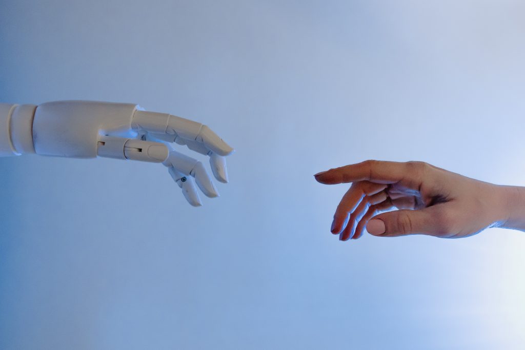 robot and human hands reaching for each other