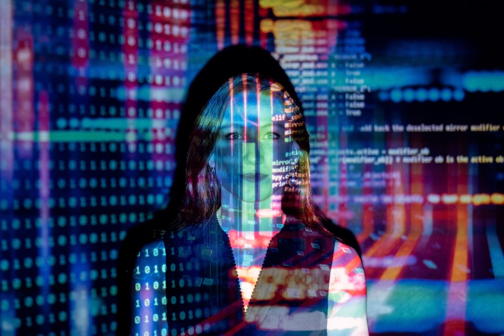 woman in front of a wall with a colorful data projection