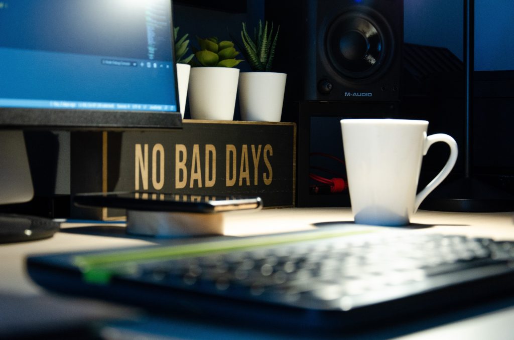 desk with "no bad days" sign and coffee mug