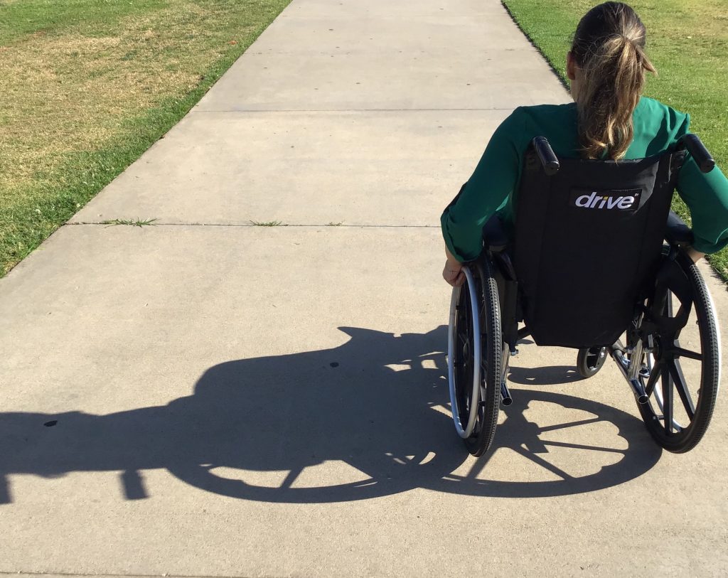 woman using wheelchair on a sidewalk