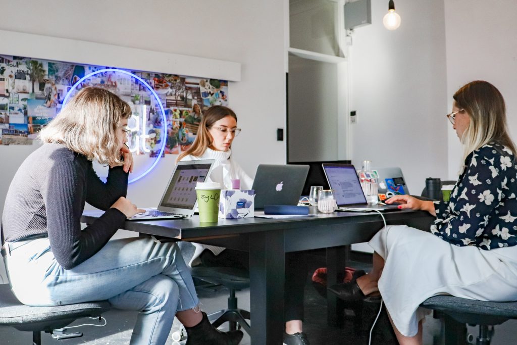 3 women working on laptops at a table