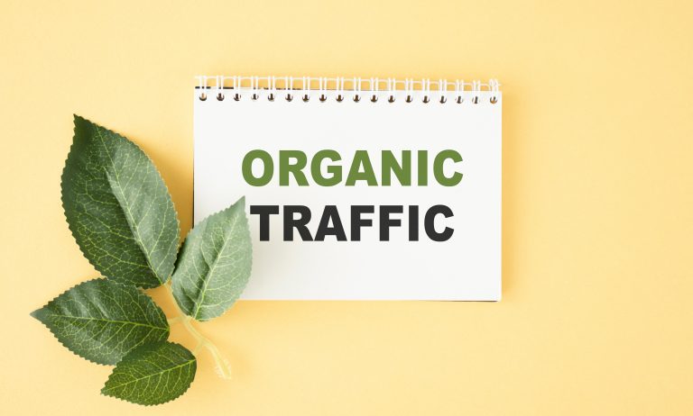 Organic traffic - business concept text on a white notebook on yellow background